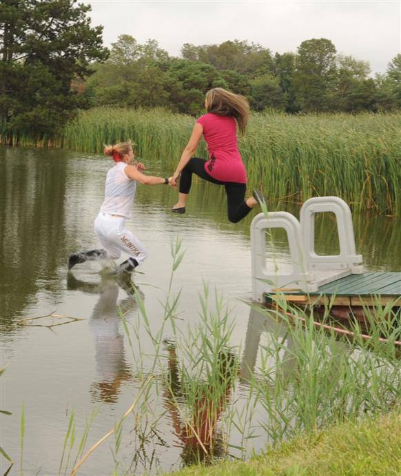 Erika Smilovsky and Lisa Caddeau take traditional jump into infield pond. 